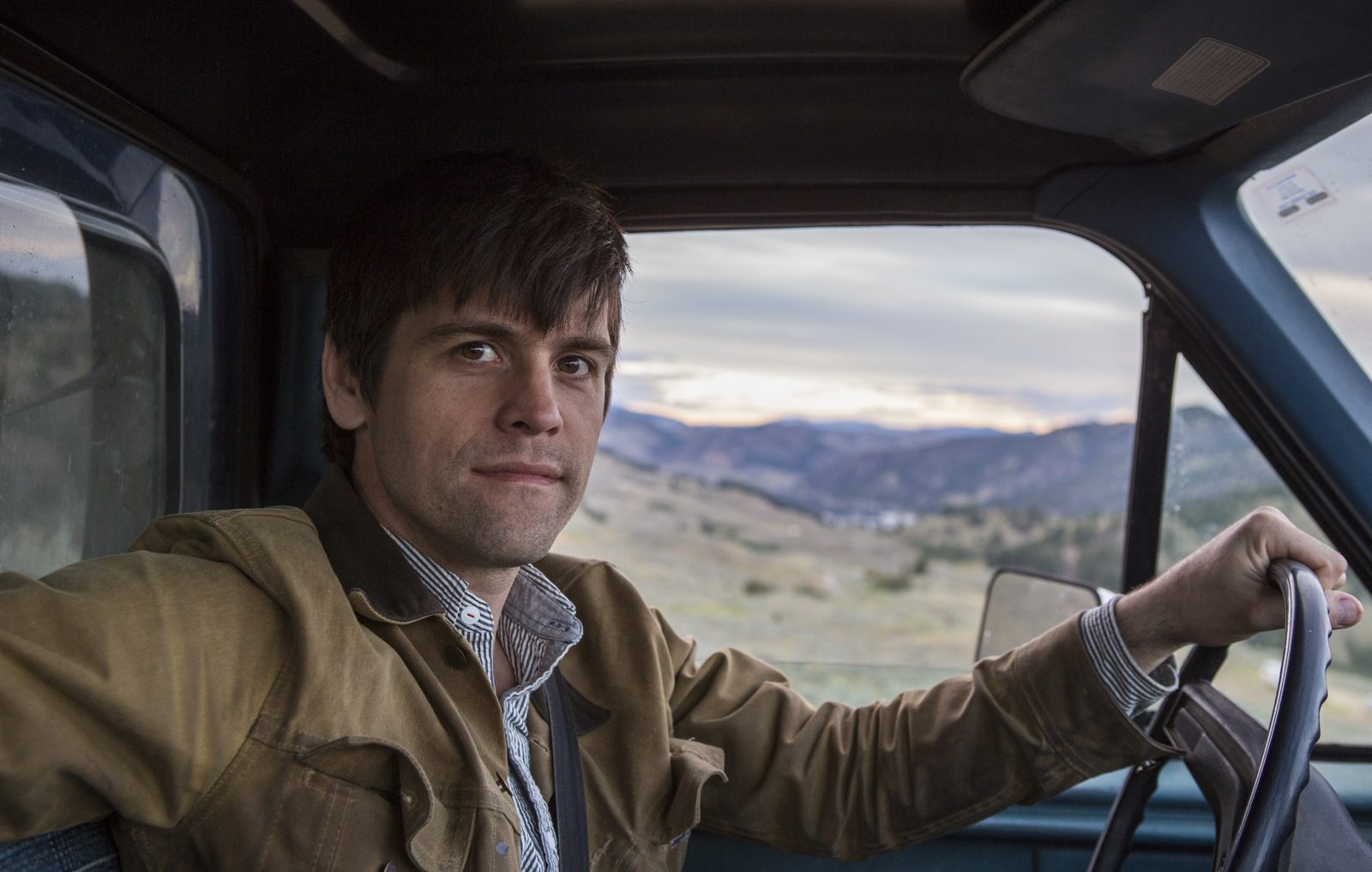 Architect Jesse Garlick at the wheel of the truck, hills behind
