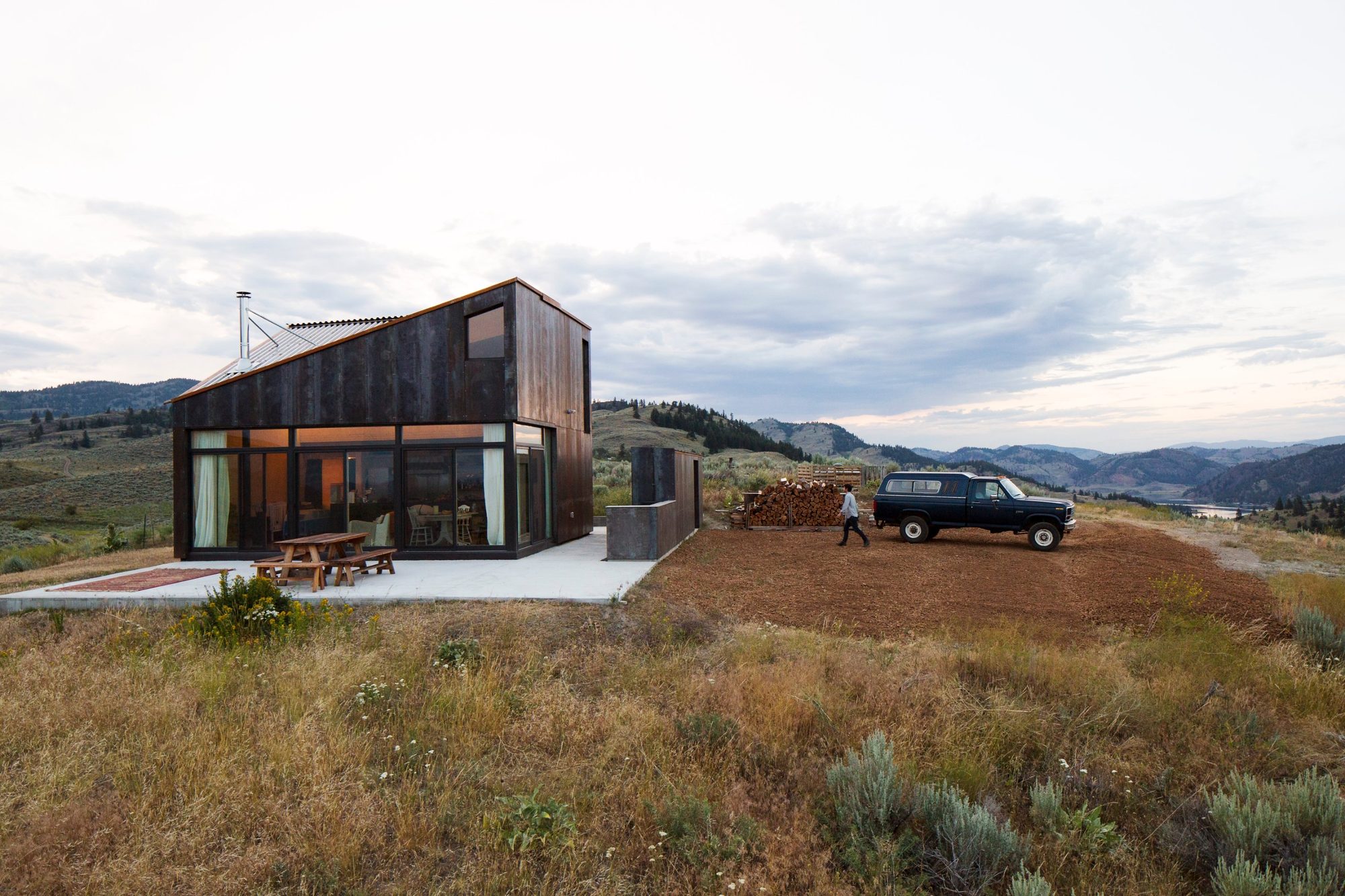 The house from across the sage meadow, truck parked nearby