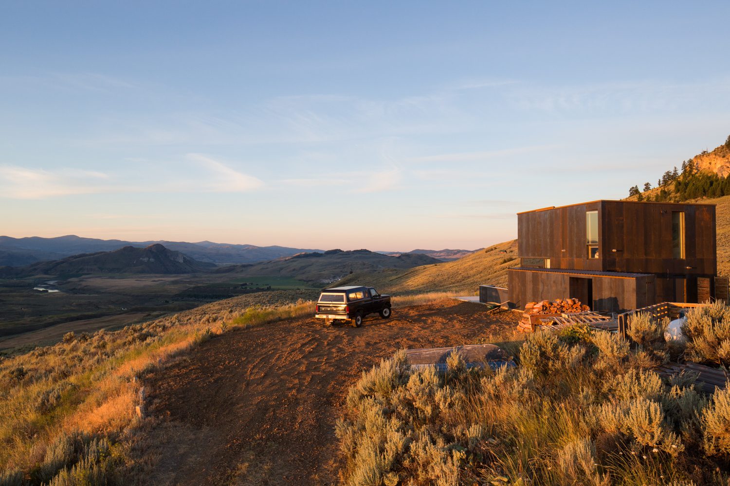 The house on its ridge at sunset, with the truck parked beside it