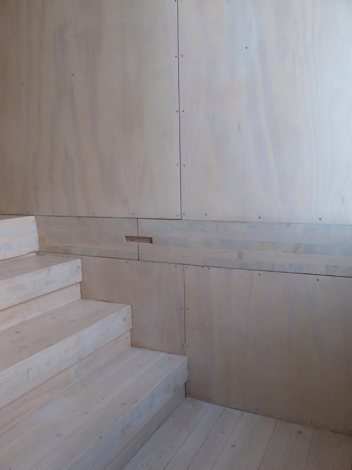Whitewashed plywood panels meeting solid timber stair treads